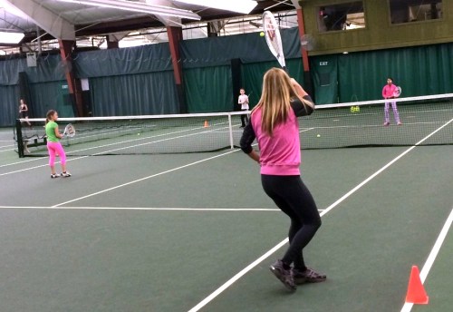 Ginny Purdy playing a forehand with daughter Chloe at the net